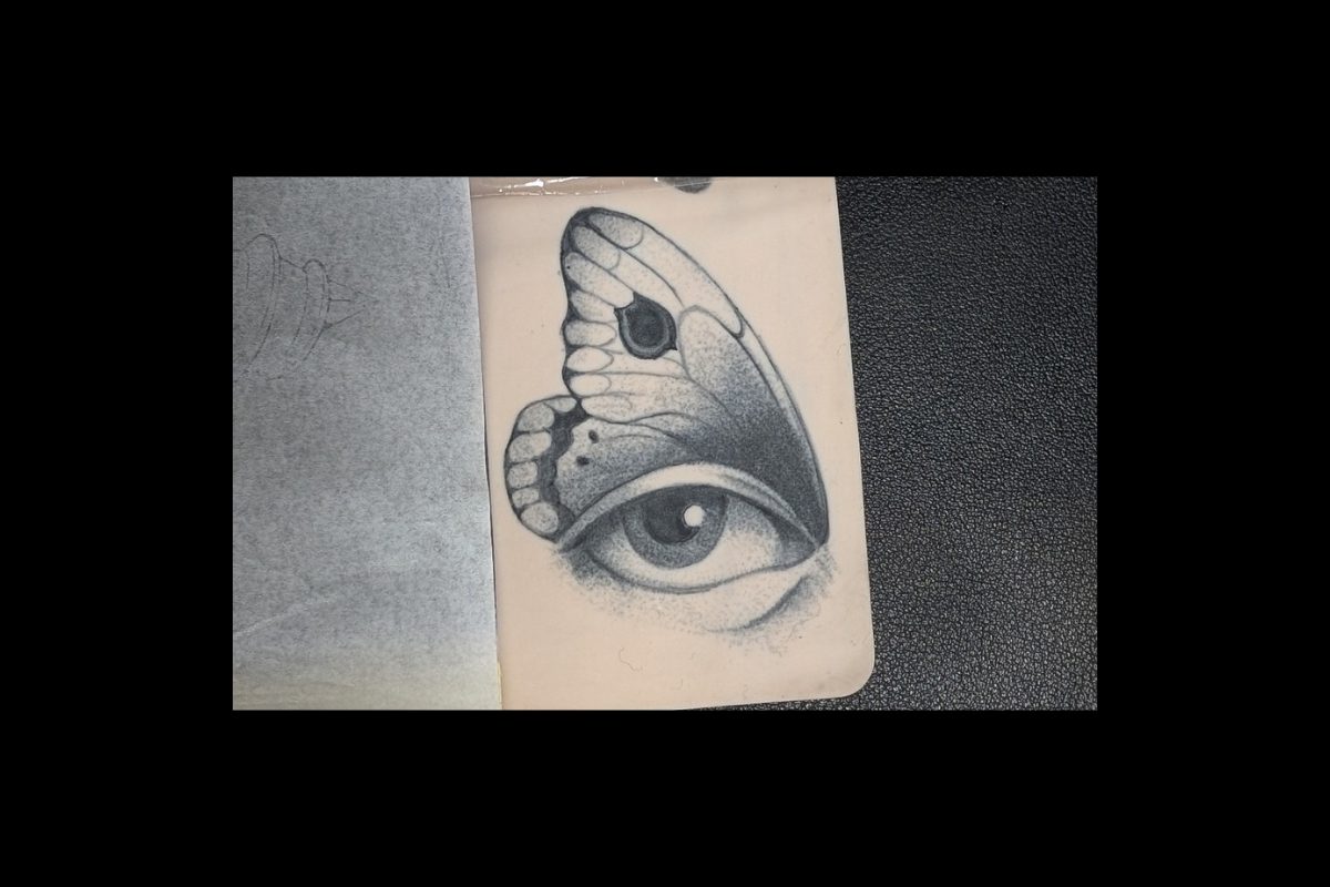 Tattoo eines Schmetterlings, dessen Flügel wie ein menschliches Auge geformt sind, fein schattiert in Grautönen